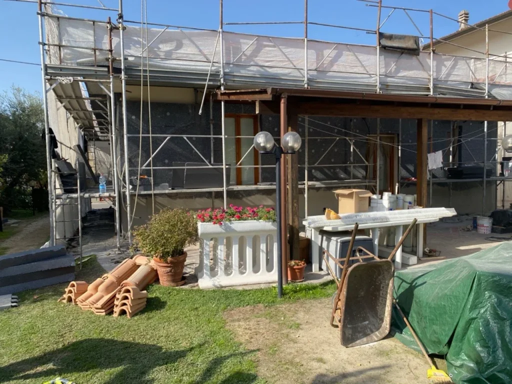 Ponteggio sulla facciata di una casa con giardino