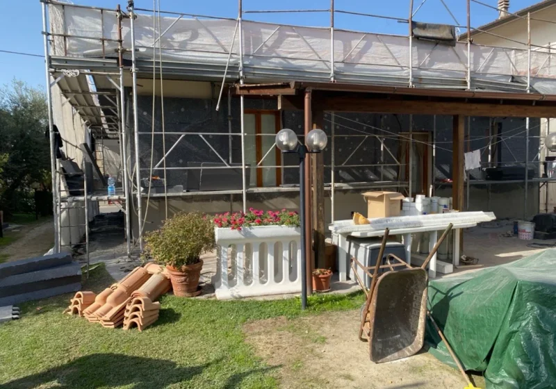 Ponteggio sulla facciata di una casa con giardino